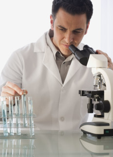 Male scientist looking at vials.