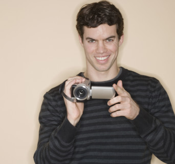 Portrait of man holding video camera.