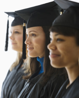 Multi-ethnic women wearing graduation cap and gown.