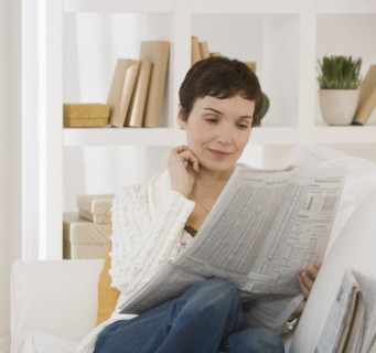 Woman reading newspaper.