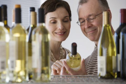 Couple looking at wine in store.