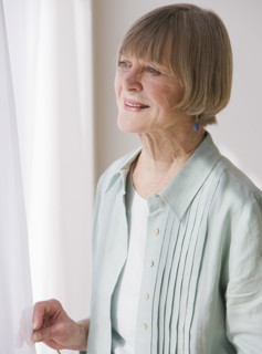 Senior woman looking out window.