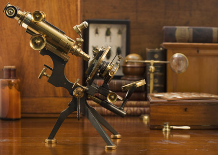 Old fashioned microscope on table.