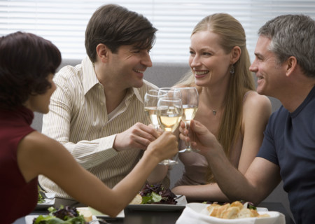 Two couples toasting at restaurant.