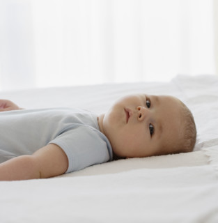 Baby laying on bed.