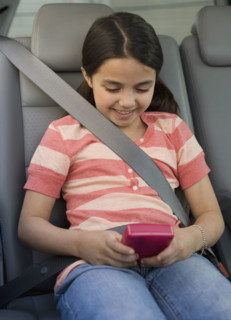 Girl playing video game in car.