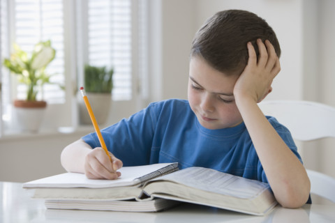 Boy doing homework at table.