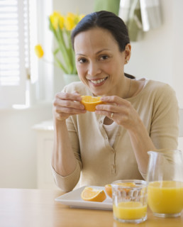 Asian woman eating oranges.