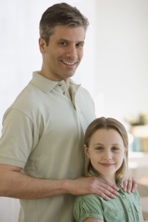 Father with hands on daughter’s shoulders.
