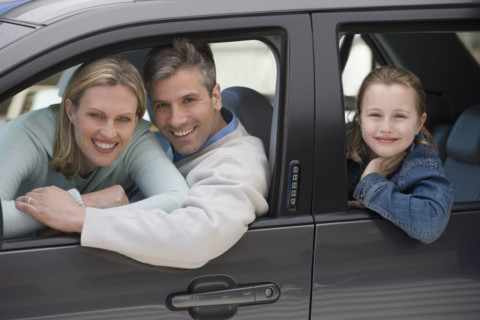 Family smiling in car.