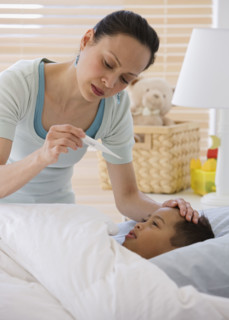 Asian mother taking son’s temperature.