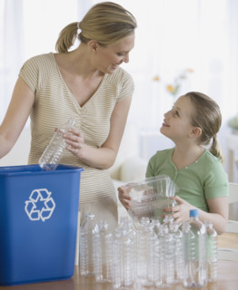 Mother and daughter filling recycle bin.