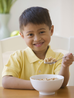 Asian boy eating cereal.