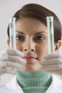 Indian female scientist looking at vials.