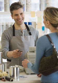 Woman paying at paint store.