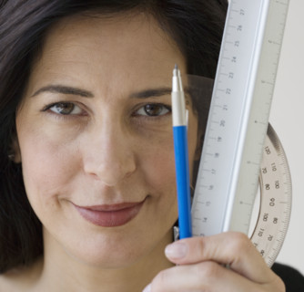 Woman holding ruler, protractor and pencil.