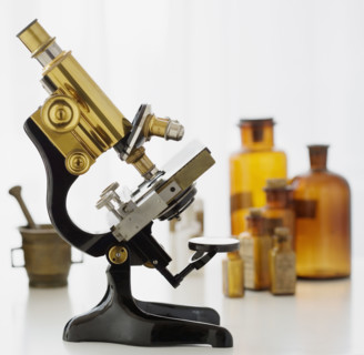 Old fashioned microscope and bottles.