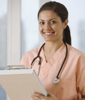 Indian female doctor writing on chart.