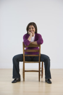 Indian woman sitting in chair backwards.