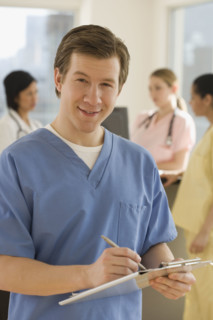 Portrait of male doctor writing on chart.