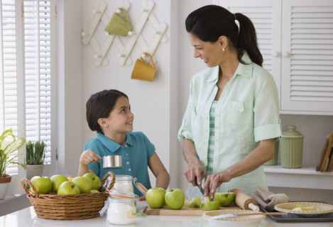 Mother and daughter making apple pie.