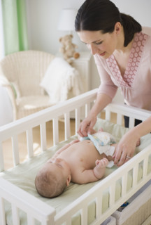 Mother changing baby’s diaper.