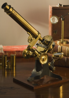 Old fashioned microscope on table.