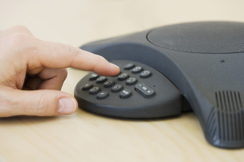 Businessman dialing conference call.