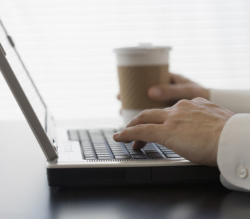 Businessman typing on laptop.