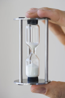 Man holding small hourglass.