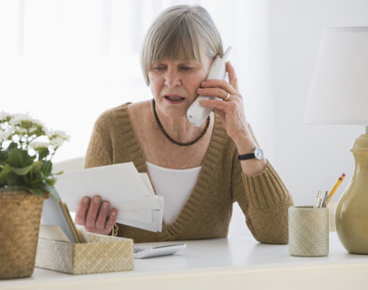 Senior woman looking at bills.
