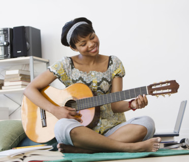 African woman playing acoustic guitar.
