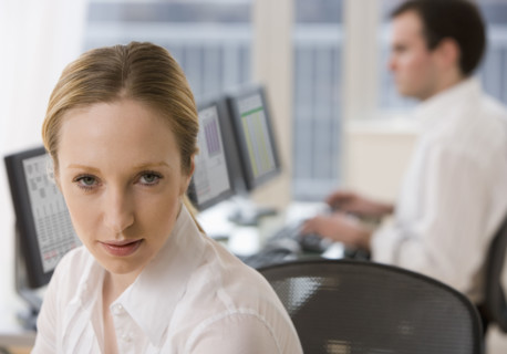 Businesswoman with co-worker in background.