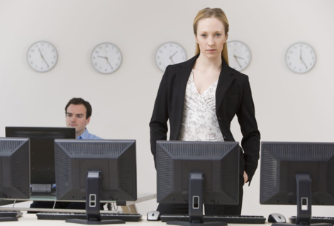 Businesswoman behind row of computers.