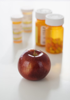 Apple in front of medication bottles.