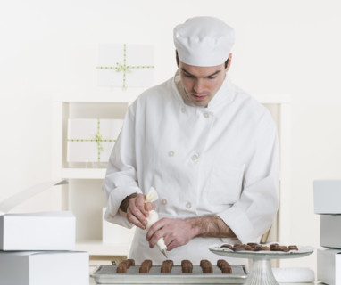 Male pastry chef in kitchen.