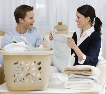 Couple folding laundry in livingroom.