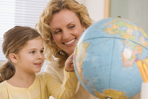 Mother and daughter looking at globe.