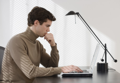 Businessman typing on laptop.