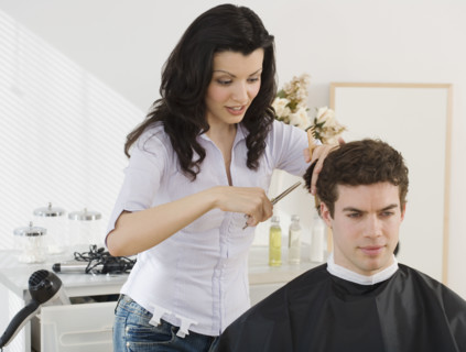 Female hair stylist cutting man’s hair.