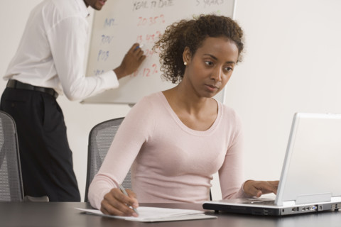 Businesswoman typing on laptop.