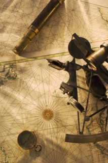 Octant, compass and telescope on nautical map.