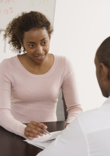 Businesswoman discussing paperwork with coworker.