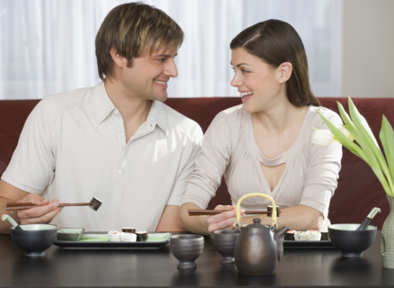 Couple smiling at each other at Japanese restaurant.