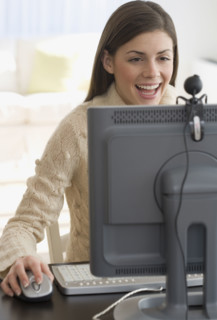 Woman smiling at webcam on computer.