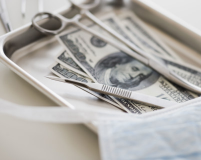Close up of surgical tools and money.