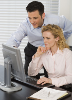 Businesspeople looking at computer.