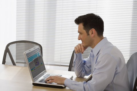 Businessman typing on laptop.