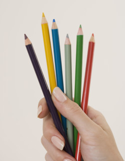 Close up of woman holding colored pencils.