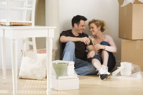 Couple drinking wine in new house.